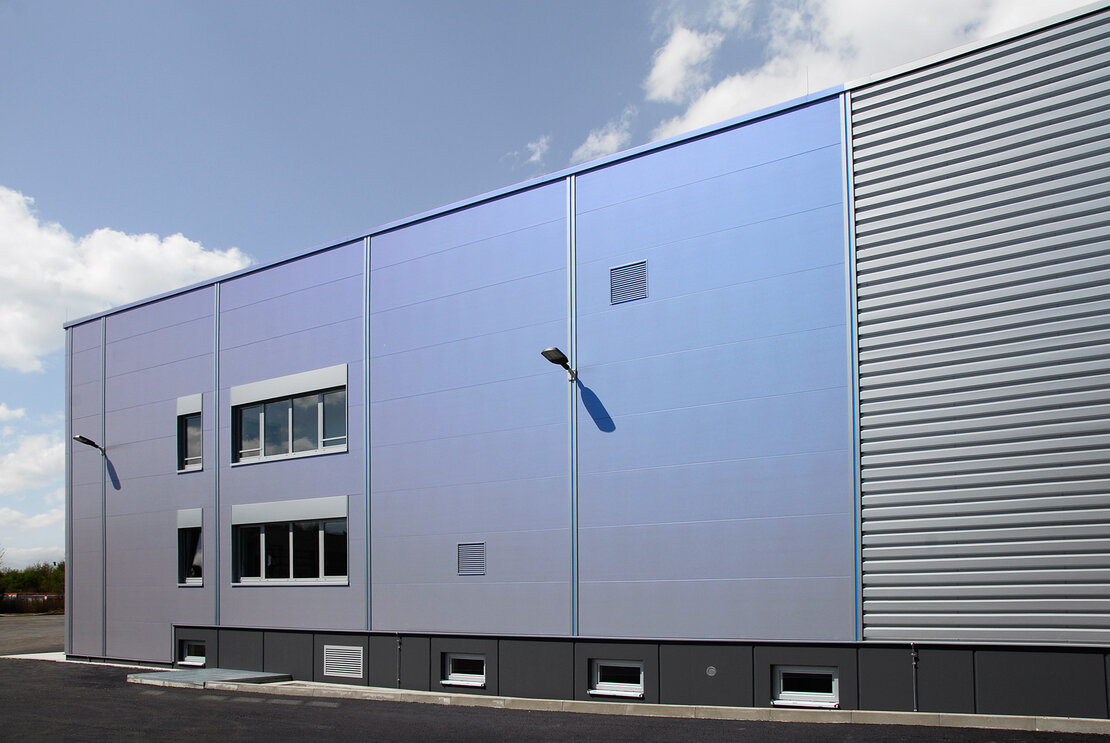 Sandwichfassade des Logistikzentrums mit irisierender Beschichtung in Grau-Violett-Blau