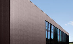 Gesamtansicht des Sportzentrums Augsburg mit mikrolinierten Roma Typ FV Paneelen und Fensterfront