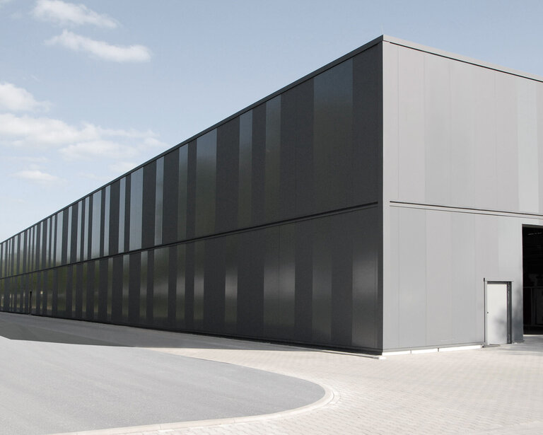 Fassade einer Produktionshalle mit Sandwichpaneelen in RAL 7012 in matter und glänzender Beschichtung