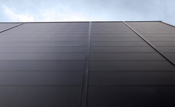 Nahaufnahme der Fassade des Logistikzentrums Wolfertschwenden mit mikrolinierten Paneelen und vertikalen Lisenen